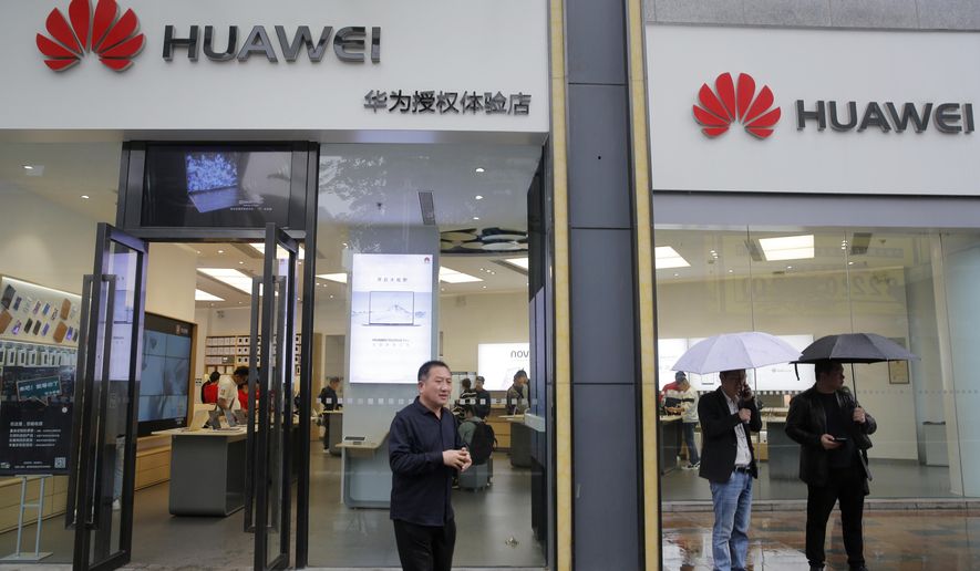 People walk past a Huawei retail shop in Shenzhen, China's Guangdong province, Thursday, March 7, 2019. Chinese tech giant Huawei is challenging a U.S. law that labels the company a security risk and would limit its access to the American market for telecom equipment. (AP Photo/Kin Cheung)