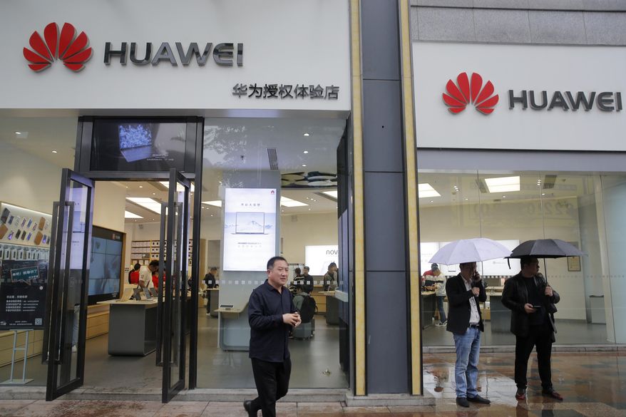 People walk past a Huawei retail shop in Shenzhen, China's Guangdong province, Thursday, March 7, 2019. Chinese tech giant Huawei is challenging a U.S. law that labels the company a security risk and would limit its access to the American market for telecom equipment. (AP Photo/Kin Cheung)