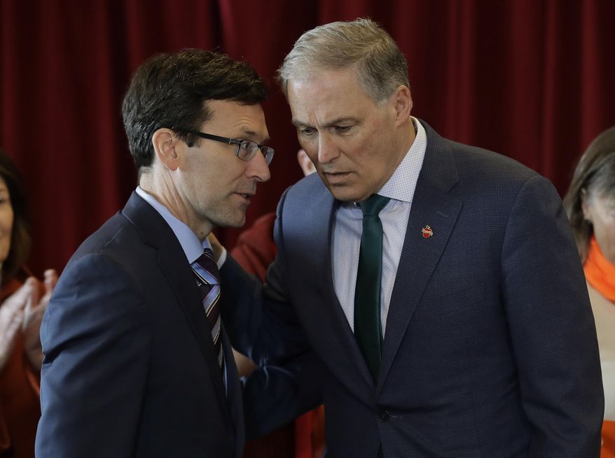 FILE - In this Feb. 14, 2019 photo, Washington Gov. Jay Inslee, right, confers with Attorney General Bob Ferguson, left, at an event in Seattle held by the Alliance for Gun Responsibility. Gov. Inslee and state attorney general Ferguson are urging gun dealers in Washington to abide by the terms of a gun control initiative that was easily passed by voters last November. Inslee and Ferguson, both Democrats, sent a letter Thursday, March 7, 2019, to 262 gun dealers who operate in counties where sheriffs have indicated they will not enforce Initiative 1639. (AP Photo/Ted S. Warren, File)