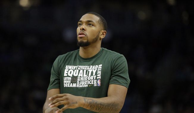 FILE - In this Feb. 9, 2019, file photo, Milwaukee Bucks&#x27; Sterling Brown warms up before the second half of an NBA basketball game against the Orlando Magic, in Milwaukee. Sterling Brown sincerely hopes his efforts to work alongside law enforcement on improving practices during arrests and stops will one day mean other black men don’t have to go through what he endured last year. Merely 13 months after being Tased by police in the wee hours at a Milwaukee Walgreen&#x27;s, Brown knows he has an important responsibility to make a difference from his experience _ even if he might never trust police again. (AP Photo/Aaron Gash, File)