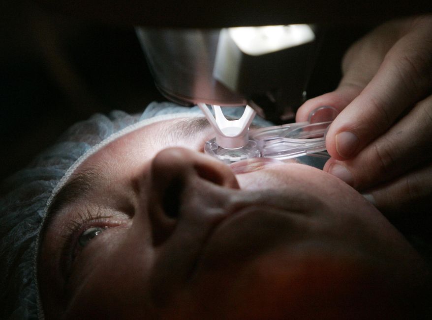 FILE - In this Nov. 1, 2005 file photo, a doctor prepares a patient for Lasik surgery in Chicago. On Friday, March 8, 2018, The Associated Press has found that stories circulating on the internet that elective Lasik surgery is offered to all female migrants to the U.S. in family detention, and children given braces, all no cost, are untrue. (AP Photo/Charles Rex Arbogast)