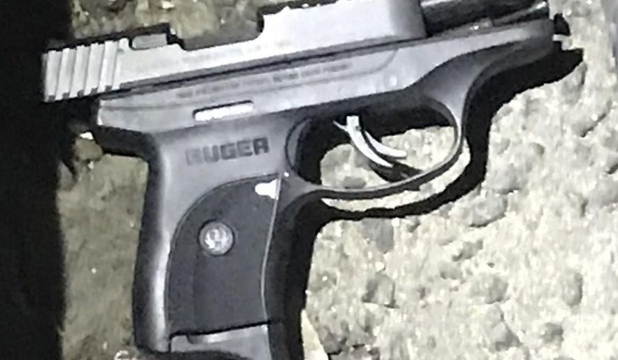 In this photo provided by the New York City Police Department, a handgun lay the ground outside the RRR Lounge in the Queens borough of New York, Saturday, March 9, 2019. Police say a man has been shot and wounded by a police officer after he shot another man outside the New York City bar with the gun and refused orders to drop the weapon. (New York City Police Department via AP)