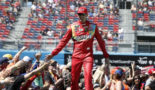 Kyle Busch is greeted by fans during driver introductions prior to the start of the NASCAR Cup Series auto race at ISM Raceway, Sunday, March 10, 2019, in Avondale, Ariz. (AP Photo/Ralph Freso) **FILE**