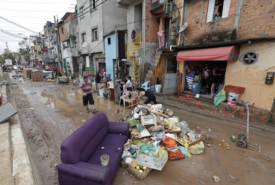 Damaged belongings, spoiled food and soaked furniture are piled up in the street to be taken away as trash after flooding in Sao Paulo, Brazil, Monday, March 11, 2019. According to The Sao Paulo state fire department, heavy rains caused the deaths of at least 11 people in and around Brazil's largest city, including a 1-year-old baby. (AP Photo/Andre Penner)
