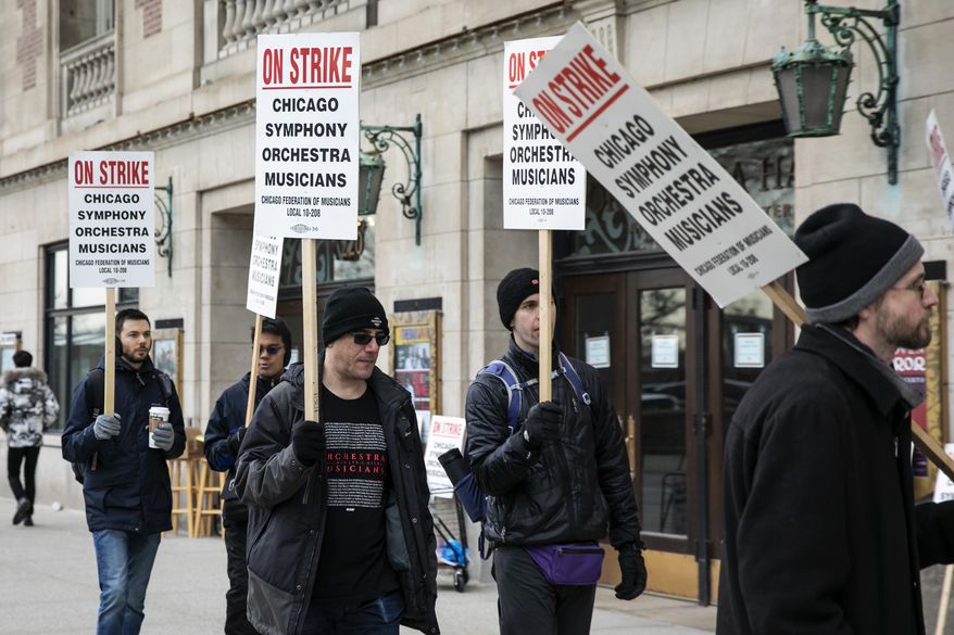 Musicians of the Chicago Symphony Orchestra go on strike and walk the picket line outside the doors of Orchestra Hall on Michigan Avenue, Monday morning, March 11, 2019. (Ashlee Rezin/Chicago Sun-Times via AP)
