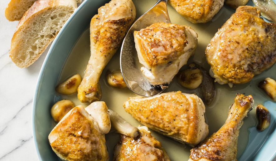 This undated photo provided by America's Test Kitchen in March 2019 shows Chicken With 40 Cloves Of Garlic. The recipe appears in the cookbook "How to Braise Everything." (Steve Klise/America's Test Kitchen via AP)
