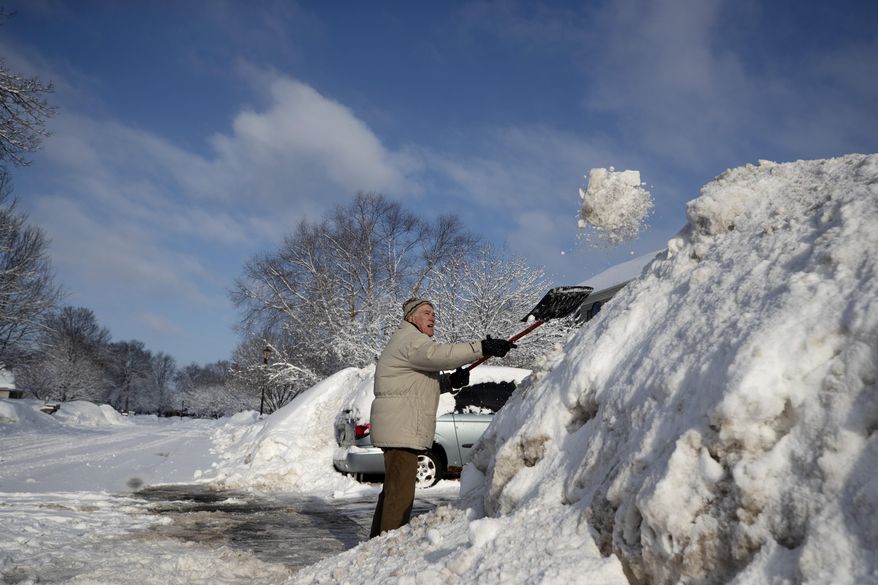Joe Rohan removes heavy wet snow from his driveway Sunday, March10, 2019 in Brooklyn Park, Minn., after a winter storm dumped more than a foot of snow in parts of the Upper Midwest. (Jerry Holt/Star Tribune via AP)