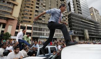 National Assembly President Juan Guaido, who declared himself interim president of Venezuela, leaps on to a vehicle to speak to supporters as he visits different points of anti-government protest in Caracas, Venezuela, Tuesday, March 12, 2019. Guaido has declared himself interim president and demands new elections, arguing that President Nicolas Maduro&#39;s re-election last year was invalid. (AP Photo/Eduardo Verdugo)