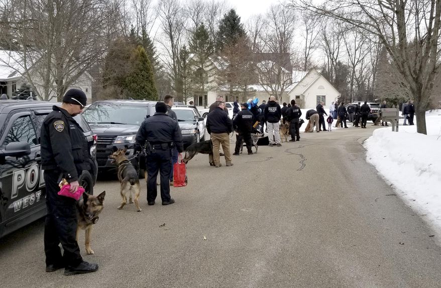 In this March 9, 2019 photo provided by the Hartford Police Department, several K9 law enforcement officers and their dogs arrive at the home of Emma Mertens in Hartford, Wis. The 7-year-old Wisconsin girl, a lover of dogs who is suffering from a potentially fatal brain tumor, got a boost of support when the officers and K9s arrived at her home. A family friend had posted a request on social media for people to send photos of their dogs. Emma's family says she has since received thousands of letters and photos from around the world. (Hartford Police Department via AP)