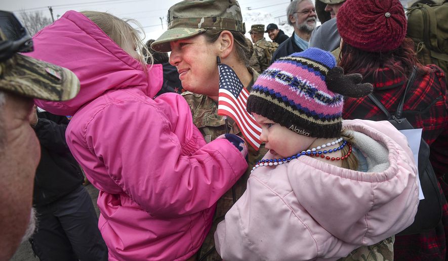 Nickole Wells hugs her daughters Nora and Amelia during a homecoming ceremony for about 160 members of the Minnesota National Guard's 851st Vertical Engineer Company Tuesday, March 12, 2019, in St. Cloud, Minn. The unit was deployed for nine months to Kuwait in support of Operation Freedom's Sentinel. During their deployment, soldiers completed construction projects in support of military units in several countries including Kuwait, Qatar, Jordan, Syria, the United Arab Emirates and Afghanistan. (Dave Schwarz/St. Cloud Times via AP)