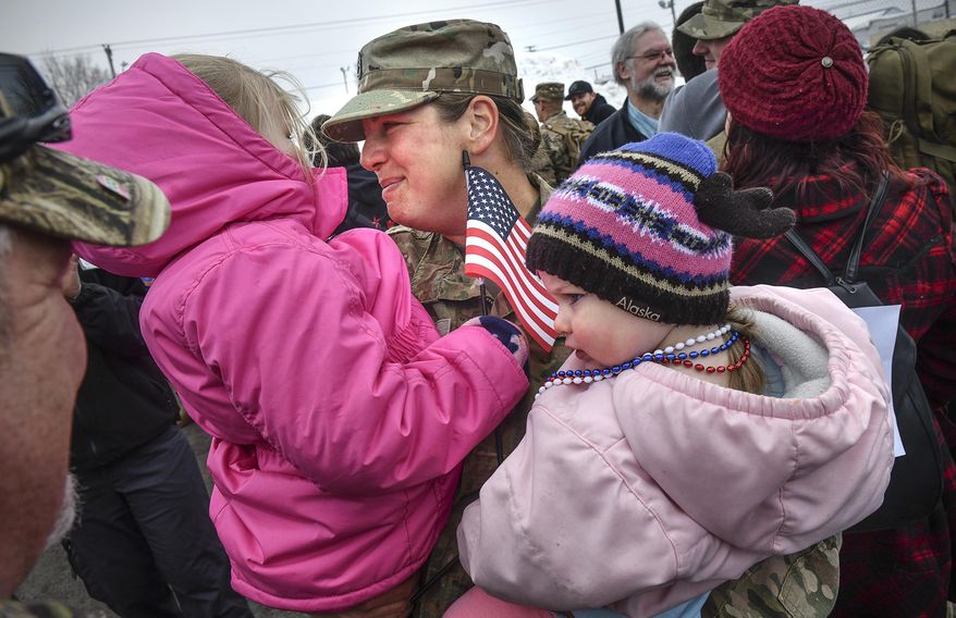 Nickole Wells hugs her daughters Nora and Amelia during a homecoming ceremony for about 160 members of the Minnesota National Guard's 851st Vertical Engineer Company Tuesday, March 12, 2019, in St. Cloud, Minn. The unit was deployed for nine months to Kuwait in support of Operation Freedom's Sentinel. During their deployment, soldiers completed construction projects in support of military units in several countries including Kuwait, Qatar, Jordan, Syria, the United Arab Emirates and Afghanistan. (Dave Schwarz/St. Cloud Times via AP)