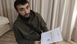 FILE - In this file photo taken on Wednesday, Nov. 14, 2018, Tumso Abdurakhmanov, the 32-year-old Chechen video blogger, and critic of the Chechen ruler Ramzan Kadyrov, holds a letter from Interpol during an interview with The Associated Press somewhere in Poland.  The speaker of Chechnya&#39;s parliament Magomedov Daudov, says he has a blood feud against the popular Chechen blogger who has fled Russia and is believed to be seeking asylum in Poland. (AP Photo/Francesca Ebel, File)