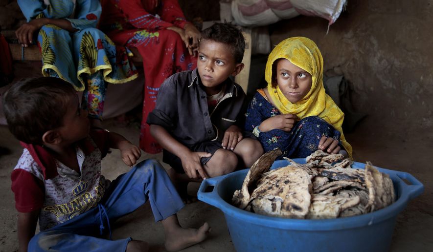 FILE - In this Oct. 1, 2018 file photo, children sit in front of moldy bread in their shelter, in Aslam, Hajjah, Yemen. The U.N. Office for the Coordination of Humanitarian Affairs, or OCHAU.N. warned in a report Tuesday, March 12, 2019, that thousands of Yemeni civilians caught in fierce clashes between warring factions are trapped in the embattled northern district of Hajjah. The number of displaced in the district has doubled over the past six months, the humanitarian agency said. (AP Photos Hani Mohammed, File)