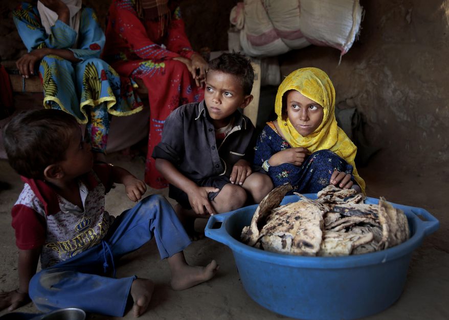FILE - In this Oct. 1, 2018 file photo, children sit in front of moldy bread in their shelter, in Aslam, Hajjah, Yemen. The U.N. Office for the Coordination of Humanitarian Affairs, or OCHAU.N. warned in a report Tuesday, March 12, 2019, that thousands of Yemeni civilians caught in fierce clashes between warring factions are trapped in the embattled northern district of Hajjah. The number of displaced in the district has doubled over the past six months, the humanitarian agency said. (AP Photos Hani Mohammed, File)