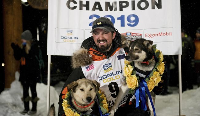 Peter Kaiser (9) poses with his lead dogs, Morrow, left, and Lucy., Wednesday, March 13, 2019, in Nome, Alaska, after winning the Iditarod Trail Sled Dog Race. It's the first Iditarod victory for Kaiser in his 10th attempt. (Marc Lester/Anchorage Daily News via AP)