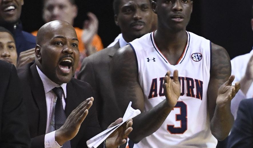 In this Jan. 19, 2019 photo, Auburn assistant coach Ira Bowman, left, cheers from the sidelines during the second half of an NCAA college basketball game against Kentucky in Auburn, Ala. Auburn has suspended Bowman indefinitely on Wednesday, March 3, 2019, amid allegations that he was involved in a bribery scheme during his time at the University of Pennsylvania. (AP Photo/Julie Bennett)