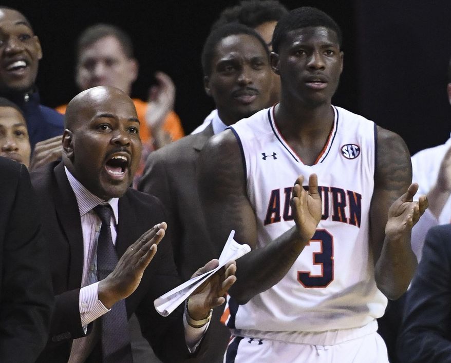 In this Jan. 19, 2019 photo, Auburn assistant coach Ira Bowman, left, cheers from the sidelines during the second half of an NCAA college basketball game against Kentucky in Auburn, Ala. Auburn has suspended Bowman indefinitely on Wednesday, March 3, 2019, amid allegations that he was involved in a bribery scheme during his time at the University of Pennsylvania. (AP Photo/Julie Bennett)