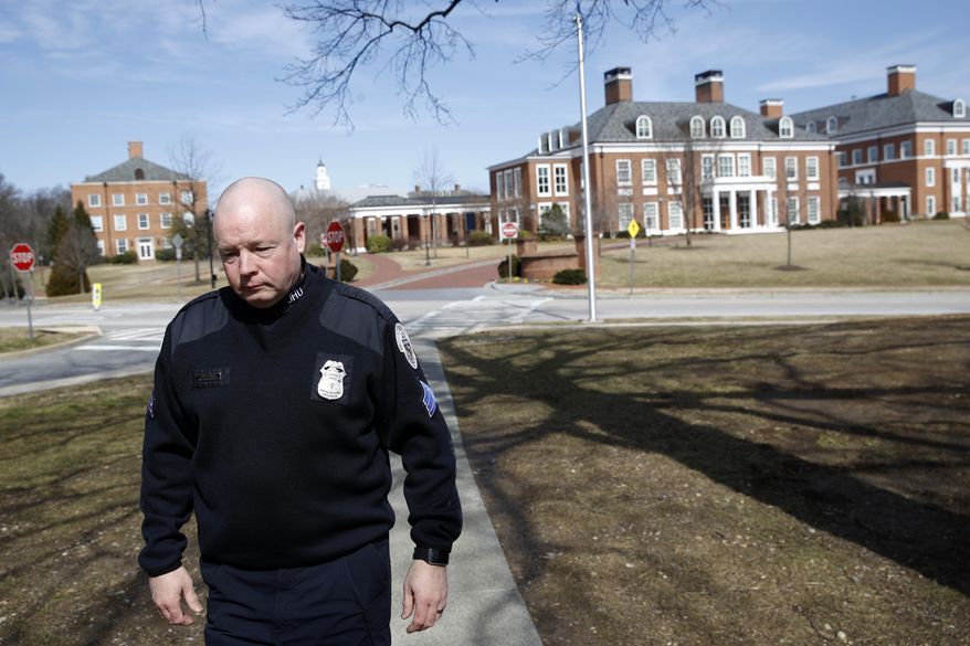 In this Feb. 26, 2019 photo, Sgt. Jason Cowger, with Johns Hopkins University's Campus Safety and Security department, walks on the university's campus in Baltimore. A bill in front of Maryland's legislature that would authorize a roughly 100-member armed police force for Johns Hopkins' three city campuses is receiving both sustained pushback and high-level endorsements a year after lawmakers were flooded with constituents' concerns and chose not to endorse an initial pitch. (AP Photo/Patrick Semansky)