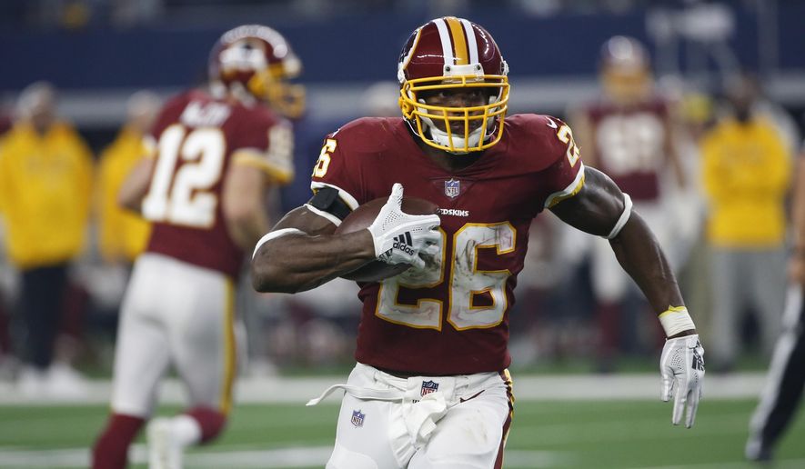 FILE - In this Nov. 22, 2018, file photo, Washington Redskins running back Adrian Peterson (26) carries against the Dallas Cowboys during the second half of an NFL football game in Arlington, Texas. A person with knowledge of the move says the Redskins agreed to re-sign Peterson to an $8 million, two-year deal. The person spoke to The Associated Press on condition of anonymity Wednesday, March 13, because the team hadn’t announced the contract. (AP Photo/Ron Jenkins) ** FILE **