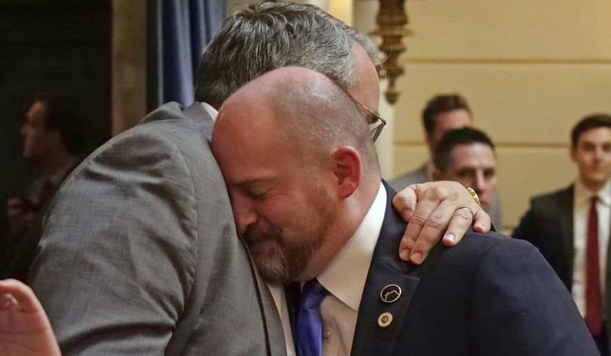 Sen. Daniel Thatcher, foreground, R-West Valley City, receives a hug from Rep. Lee Perry, R-Perry, on the Senate floor following a vote Wednesday, March 13, 2019, in Salt Lake City. A once-stalled measure to strengthen Utah's hate crime law has passed the Legislature and is poised to become law. The Utah Senate cast the final vote to pass the measure, and Republican Gov. Gary Herbert said he's looking forward to signing it. (AP Photo/Rick Bowmer)