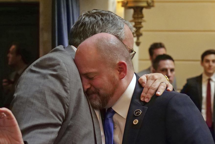 Sen. Daniel Thatcher, foreground, R-West Valley City, receives a hug from Rep. Lee Perry, R-Perry, on the Senate floor following a vote Wednesday, March 13, 2019, in Salt Lake City. A once-stalled measure to strengthen Utah's hate crime law has passed the Legislature and is poised to become law. The Utah Senate cast the final vote to pass the measure, and Republican Gov. Gary Herbert said he's looking forward to signing it. (AP Photo/Rick Bowmer)