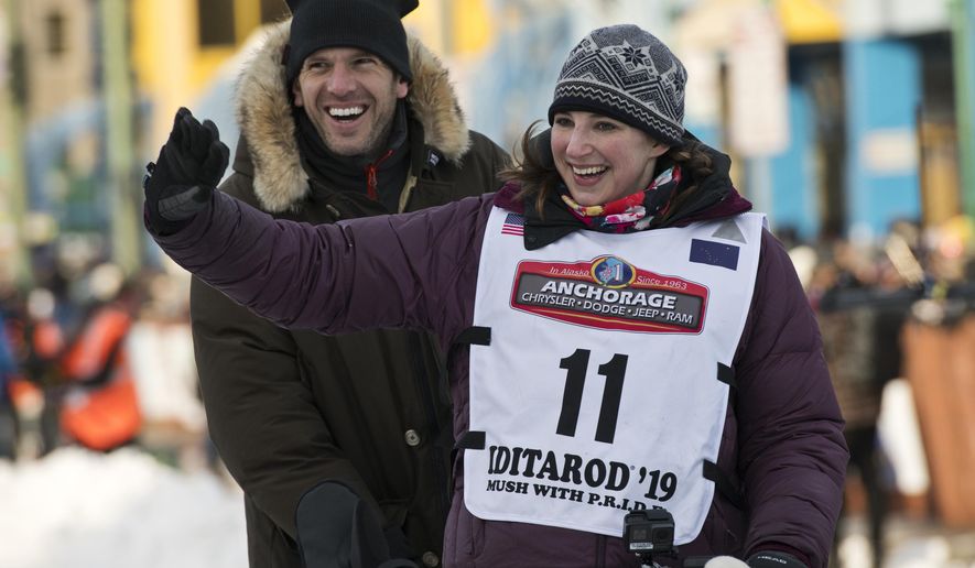 In this Saturday, March 2, 2019, photo, rookie musher Blair Braverman, right, leaves the starting line on Fourth Avenue, in Anchorage, Alaska, for the ceremonial start of the Iditarod. Riding behind her is composer and pianist Yotam Haber. (Marc Lester/Anchorage Daily News via AP)