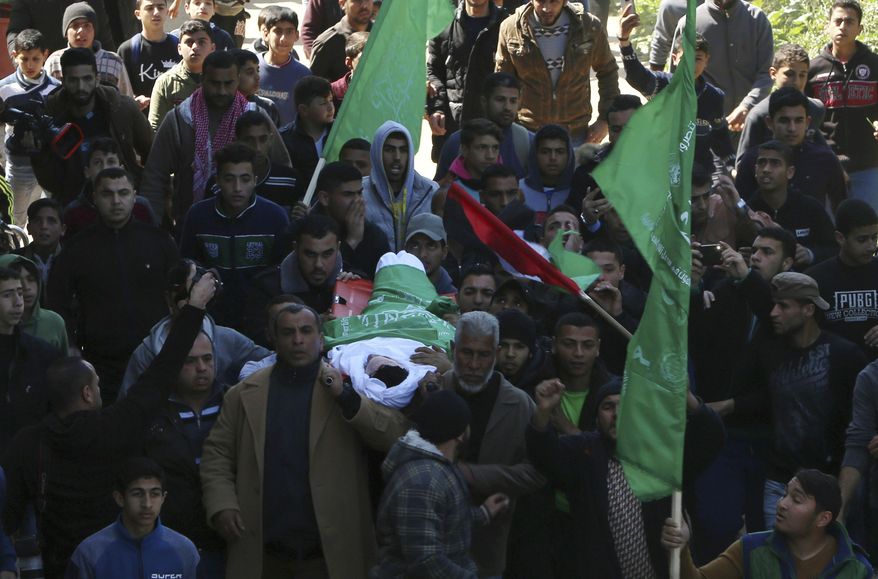 Mourners carry the body of Saif Abu Zaied, 15, during his funeral though the streets of Gaza City, Thursday, March 7, 2019. Gaza's Health Ministry said Abu Zaied died from Israeli gunfire during nighttime skirmishes along the Gaza-Israel frontier last night. (AP Photo/Adel Hana)