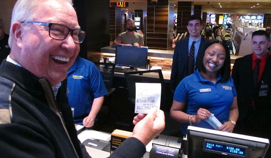 Former Philadelphia Eagles quarterback Ron Jaworski holds a ticket showing his $100 bet on the Philadelphia Phillies to win the 2019 World Series at the Tropicana casino in Atlantic City N.J. on March 8, 2019. Figures released on March 13, 2019 show New Jersey gamblers have wagered almost $2 billion on sporting events since it started nine months ago. (AP Photo/Wayne Parry)