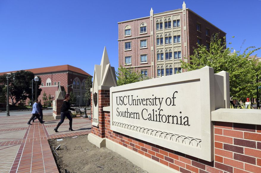 This Tuesday, March 12, 2019 photo shows the University Village area of the University of Southern California in Los Angeles. USC is one of many colleges and companies moving swiftly to distance themselves from employees swept up in a nationwide college admissions scheme, many charged with taking bribes and others from well-to-do and celebrity parents accused of angling to get their children into top schools. By Wednesday, March 13, USC had fired senior associate athletic director Donna Heinel and water polo coach Jovan Vavic. USC's interim President Wanda Austin said about a half-dozen current applicants affiliated with Singer's firm will be barred from admission. (AP Photo/Reed Saxon)may be connected to the scheme alleged by the government. (AP Photo/Reed Saxon) **FILE**
