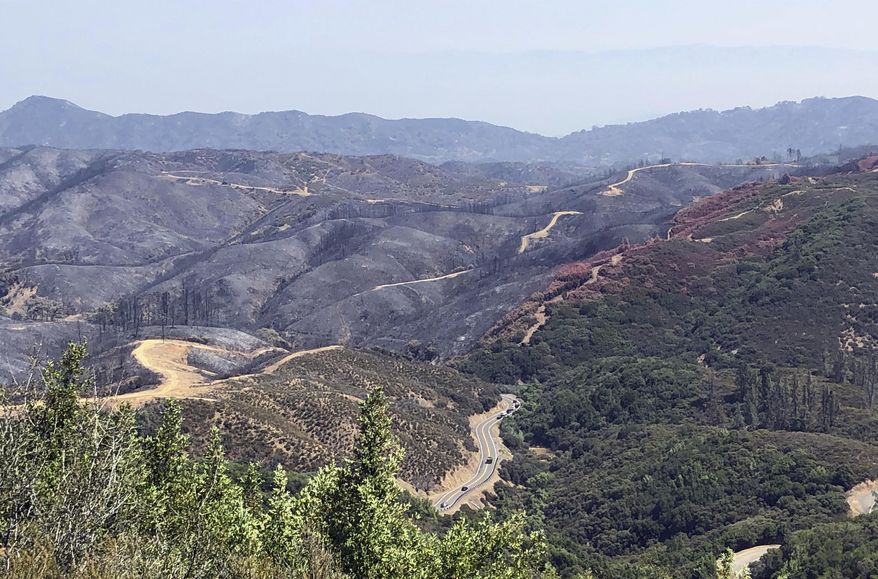 FILE - This Aug. 10, 2018, file photo, taken near Lakeport, Calif. shows dirt paths created by bulldozers in an effort to contain part of the largest wildfire on record in California. An environmentalist group is questioning the use of bulldozers to fight major wildfires, saying they're ineffective and leave lasting environmental damage. The Firefighters United for Safety, Ethics, & Ecology organization released a report Thursday, March 14, 2019, detailing bulldozers' use during a Northern California wildfire in July. (AP Photo/Jonathan J. Cooper, File)