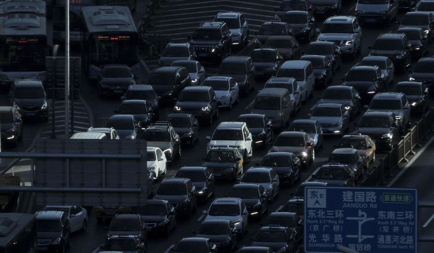 FILE - In this Dec. 11, 2018, file photo, a beam of sunlight is cast on vehicles on a city ring-road clogged with heavy traffic during the morning rush hour in Beijing. The downturn in China’s auto market worsened in January and February as sales plunged 17.5 percent from a year earlier. (AP Photo/Andy Wong, File)