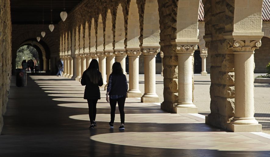 Students walk on the Stanford University campus Thursday, March 14, 2019, in Santa Clara, Calif. In the first lawsuit to come out of the college bribery scandal, several students are suing Yale, Georgetown, Stanford and other schools involved in the case, saying they and others were denied a fair shot at admission. The plaintiffs brought the class-action complaint Wednesday, March 13, 2019, in federal court in San Francisco on behalf of themselves and other applicants and asked for unspecified damages. (AP Photo/Ben Margot)