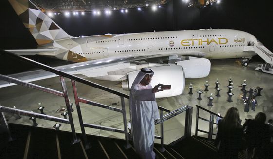 FILE - In this Dec. 18, 2014 file photo, an Emirati man takes a selfie in front of a new Etihad Airways A380 in Abu Dhabi, United Arab Emirates. The Abu Dhabi-based long-haul carrier Etihad Airways said Thursday, March 14, 2019 it lost $1.28 billion in 2018, the third consecutive year of losses of over a billion dollars. (AP Photo/Kamran Jebreili, File)