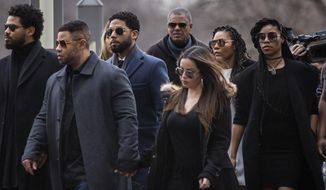 Empire actor Jussie Smollett, center, arrives at the Leighton Criminal Court Building for his hearing on Thursday, March 14, 2019, in Chicago. Smollett is accused of lying to police about being the victim of a racist and homophobic attack by two men on Jan. 29 in downtown Chicago.  (Ashlee Rezin/Chicago Sun-Times via AP)