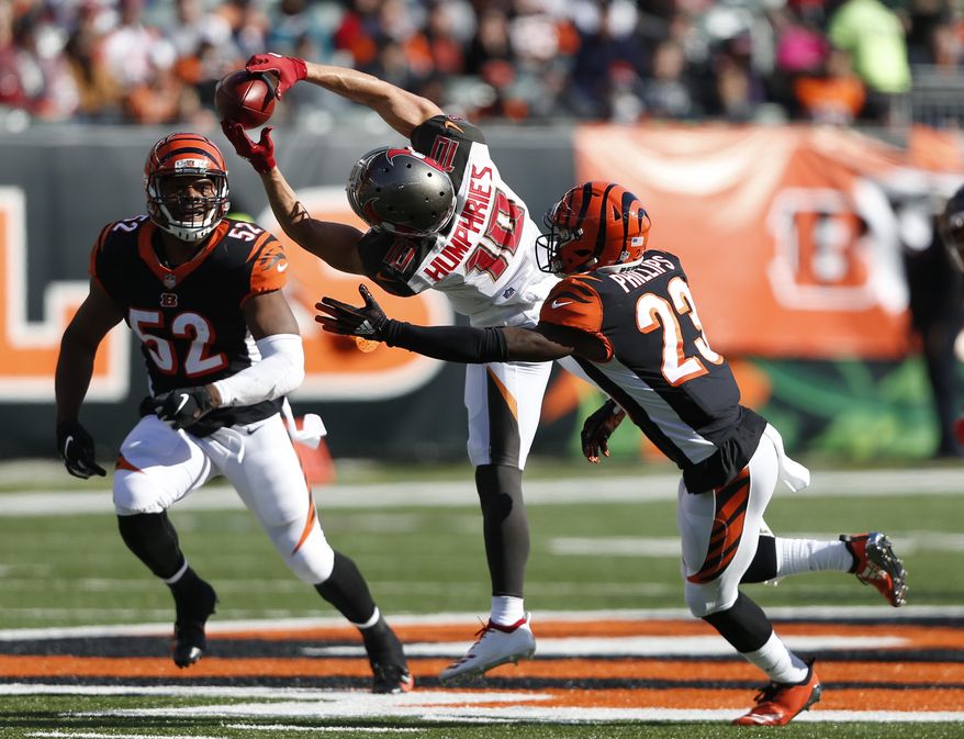 FILE - In this Oct. 28, 2018,. file photo, Tampa Bay Buccaneers wide receiver Adam Humphries (10) makes a catch between Cincinnati Bengals cornerback Darius Phillips (23) and linebacker Preston Brown (52) during the second half of an NFL football game, in Cincinnati. For Adam Humphries, Tennessee has been a potential destination for months based on his relationship with Titans general manager Jon Robinson because of their Tampa Bay connection. Not even a late push by the New England Patriots could sway him to walk away from his deal with the Titans. Even considering how much success wide receivers like Humphries have enjoyed with the defending Super Bowl champs.“Obviously, I’m a man of my word, and I’m going to keep my word there,” Humphries said Thursday, March 14, 2019, after signing with Tennessee. (AP Photo/Frank Victores, File)