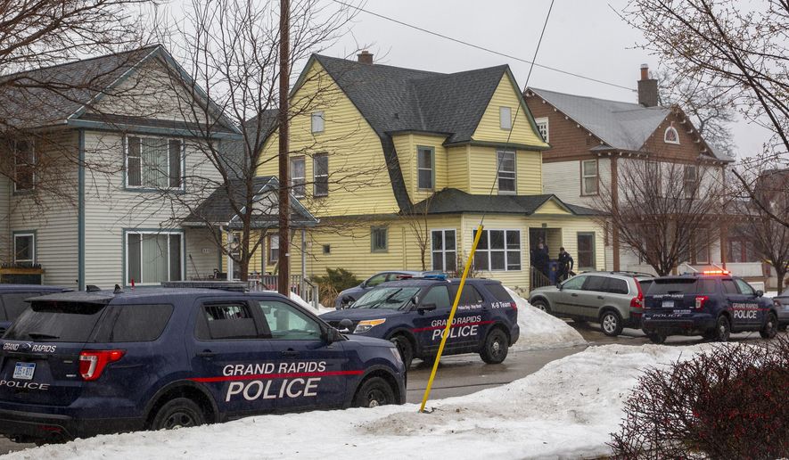Grand Rapids Police arrive to investigate two suspicious deaths at a home in Grand Rapids, Mich, on Wednesday, March 13, 2019. Police say forensics personnel have been working on the investigation since a call came in Wednesday that brought authorities to the home. (Cory Morse/The Grand Rapids Press via AP)