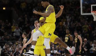 Michigan&#39;s Charles Matthews, front, celebrates with Zavier Simpson after scoring a 3-point basket during the first half of an NCAA college basketball game against the Iowa in the quarterfinals of the Big Ten Conference tournament, Friday, March 15, 2019, in Chicago. (AP Photo/Nam Y. Huh)
