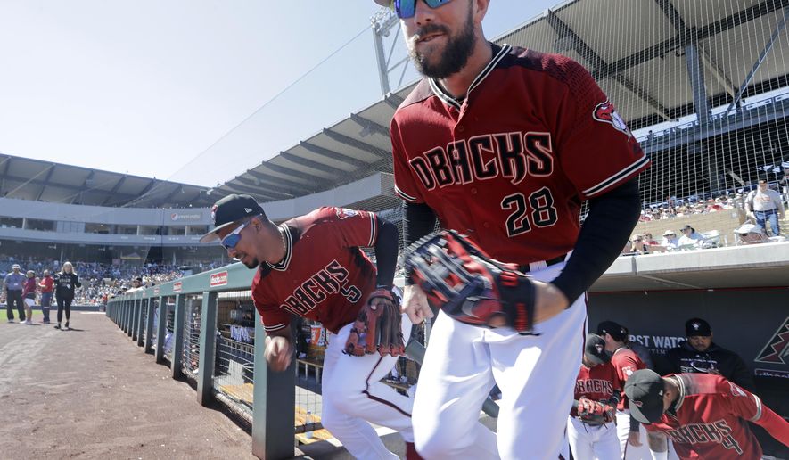 Arizona Diamondbacks' Steven Souza Jr. (28) and Eduardo Escobar (5) lead players out of the dugout before a spring training baseball game against the San Francisco Giants Thursday, March 14, 2019, in Scottsdale, Ariz. (AP Photo/Elaine Thompson)