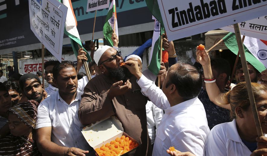 FILE - In this Feb. 26, 2019, file photo, Indians offer sweets to each other as they celebrate reports of Indian aircrafts bombing Pakistan territory in Mumbai, India. A standoff with nuclear rival Pakistan appears to have given Indian Prime Minister Narendra Modi, the head of India&#39;s Hindu nationalist Bharatiya Janata Party-led government, a boost ahead of national elections set to begin in April. Making the most of the confrontation with Pakistan and his party’s efforts to project him as a strong leader, Modi has been crisscrossing India addressing rallies and claiming that his government’s response to the suicide bombing shows that a “New India” is emerging. (AP Photo/Rafiq Maqbool)