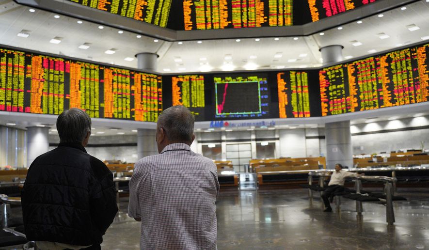 Visitors stand in front of private stock trading boards at a private stock market gallery in Kuala Lumpur, Malaysia, Friday, March 15, 2019. Shares were higher Friday in Asia after a day of lackluster trading on Wall Street. (AP Photo/Yam G-Jun)