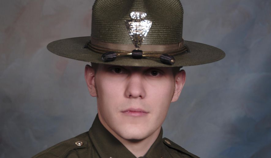 This undated booking photo provided by the Montana Highway Patrol shows Montana Highway Patrol Trooper Wade Palmer. Authorities say Palmer is in critical condition after being shot while investigating an earlier shooting in Missoula. Highway Patrol officials said in a statement Friday, March 15, 2019, another trooper found the wounded 35-year-old Palmer in his patrol car outside a bar in Evaro, Mont. early Friday. (Montana Highway Patrol via AP)