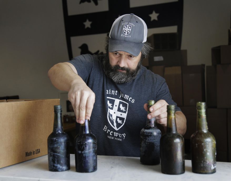 In this March 4, 2019, photo, Jamie Adams shows some intact beer bottles recovered from the shipwreck of the SS Oregon at his St. James Brewery in Holbrook, N.Y. Adams created an ale called Deep Ascent using the yeast from the bottles recovered from the Liverpool-to-New York luxury liner that sank off Fire Island in 1886. (AP Photo/Seth Wenig)