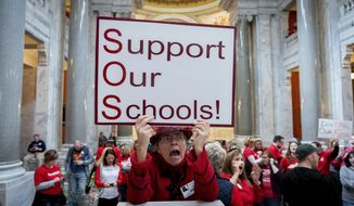 Karen Schwartz, a teacher at Phoenix School of Discovery in Louisville, stands with other teaches and their supporters to protest perceived attacks on public education, in Frankfort, Ky, Tuesday, March 12, 2019. (AP Photo/Bryan Woolston)