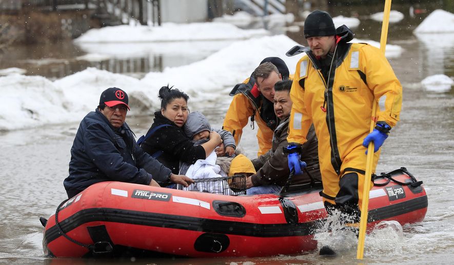 Green Bay firefighters assist residents in evacuating their homes due to the East river flooding on Friday, March 15, 2019 in Green Bay, Wis. Heavy rain falling atop deeply frozen ground has prompted evacuations along swollen rivers in Wisconsin, Nebraska and other Midwestern states, while powerful wind and snow has impacted hundreds of miles of interstates in North Dakota. (Adam Wesley/The Post-Crescent via AP)