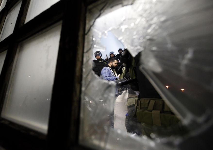 Serbian police officers escort a protester against the autocratic rule of Serbian President Aleksandar Vucic into state-run TV headquarters in Belgrade, Serbia, Saturday, March 16, 2019. Riot police arrived at the scene in downtown Belgrade and were trying to evict dozens who had entered the downtown building. (AP Photo/Darko Vojinovic)