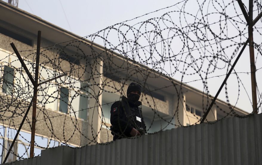 A member of Afghan security forces stands guard after Monday&#39;s Christmas Eve attack, in Kabul, Afghanistan, Tuesday, Dec. 25, 2018. A suicide bomber and gunmen armed with assault rifles and explosives attacked the building in Kabul on Monday, setting off an eight-hour-long siege. (AP Photo/Rahmat Gul)