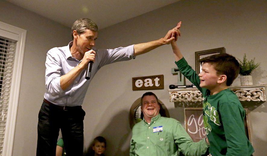 Democratic presidential candidate Beto O'Rourke high-fives Mitchell Murphy, 12, while he speaks at an event at the home of Dubuque County Recorder John Murphy in Dubuque, Iowa on Saturday, March 16, 2019. (Eileen Meslar/Telegraph Herald via AP)