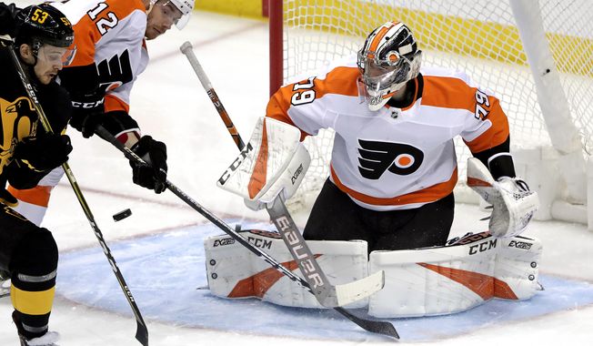 Pittsburgh Penguins&#x27; Teddy Blueger (53) can&#x27;t get his stick on a rebound in front of Philadelphia Flyers goaltender Carter Hart (79) with Michael Raffl (12) defending during the first period of an NHL hockey game in Pittsburgh, Sunday, March 17, 2019. (AP Photo/Gene J. Puskar)