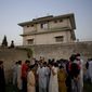 In this May 3, 2011, file photo, local residents gather outside a house where al Qaeda leader Osama bin Laden was killed in Abbottabad, Pakistan. (AP Photo/B.K.Bangash, File)