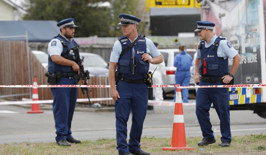 Police officials stand guard as religious representatives perform a special blessing ceremony on the site of Friday's shooting outside the Linwood mosque in Christchurch, New Zealand, Monday, March 18, 2019. Three days after Friday's attack, New Zealand's deadliest shooting in modern history, relatives were anxiously waiting for word on when they can bury their loved ones. (AP Photo/Vincent Thian)